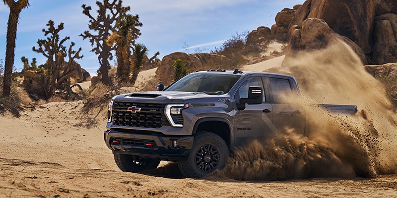A 2024 Chevrolet Silverado driving through the dirt