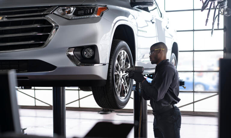 Technician with impact wrench working on tire